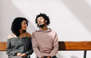 two people sitting at a bench