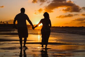 couple-standing-on-body-of-water-during-golden-hour