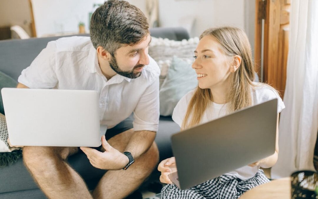 man-and-woman-holding-their-laptops
