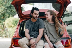 couple-relaxing-after-unpacking-car-while-moving-home