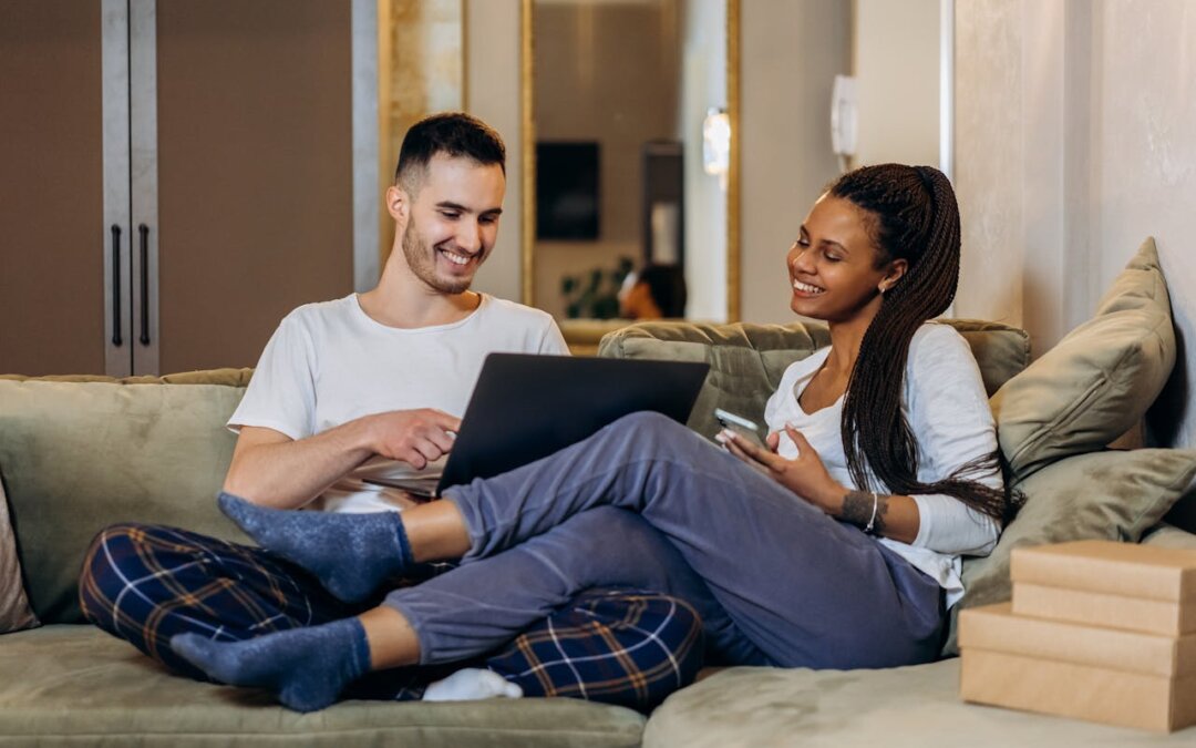 man-and-woman-sitting-on-green-sofa-using-laptop