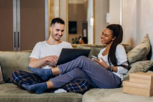 man-and-woman-sitting-on-green-sofa-using-laptop