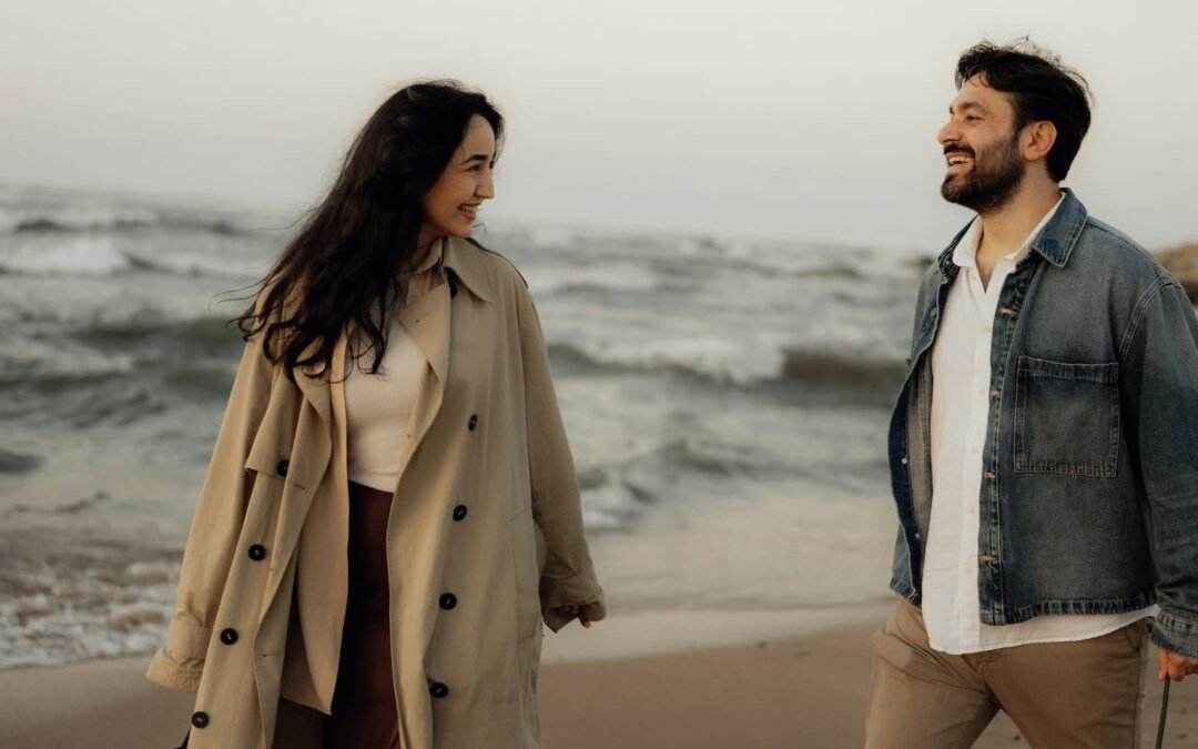 a-couple-smiles-at-each-other-on-the-beach