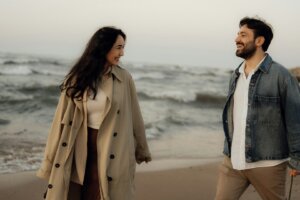 a-couple-smiles-at-each-other-on-the-beach